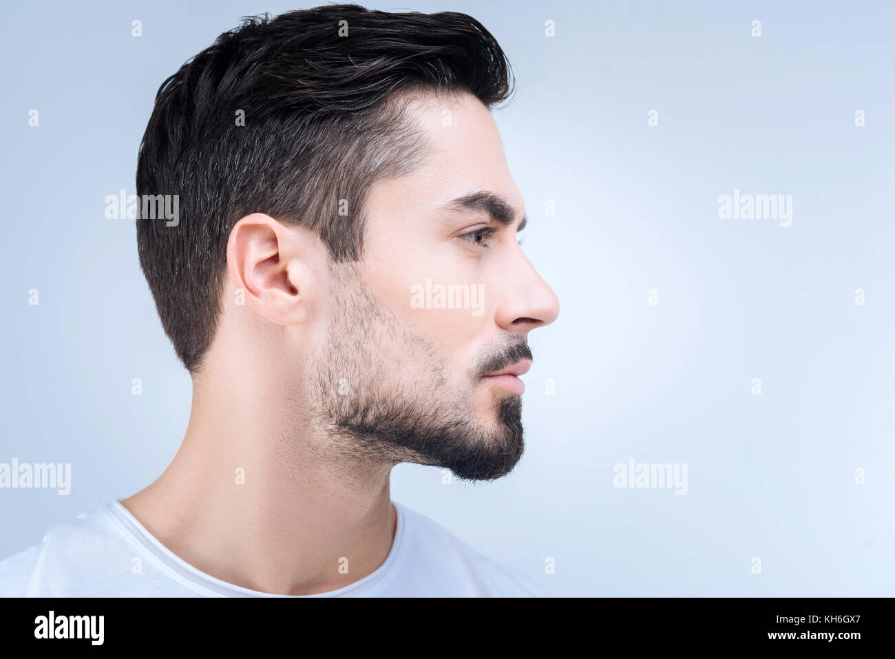 Unemotional young man showing his new haircut Stock Photo