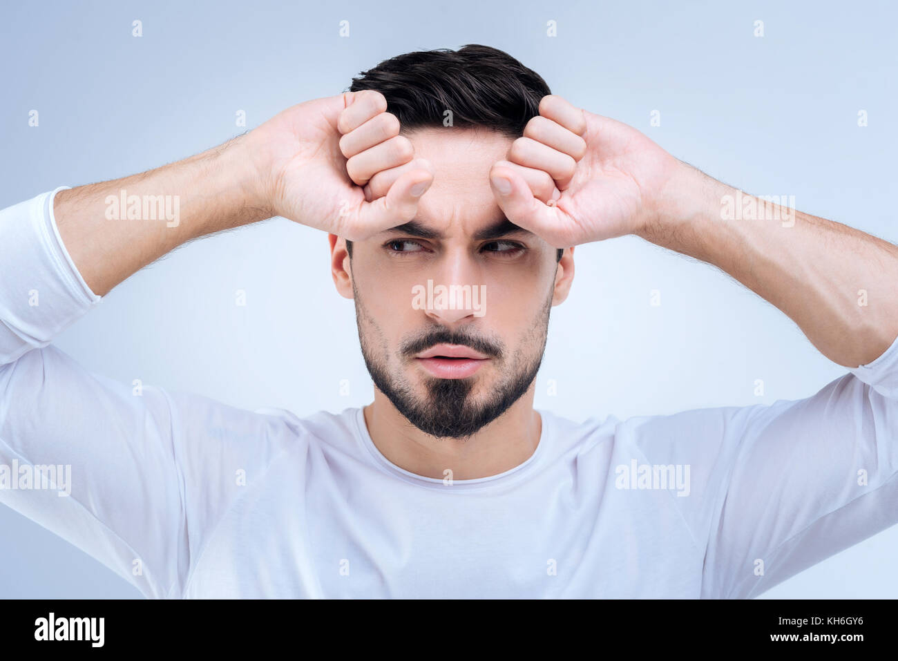 Young confident man having a suspicion about the strange situation at work Stock Photo
