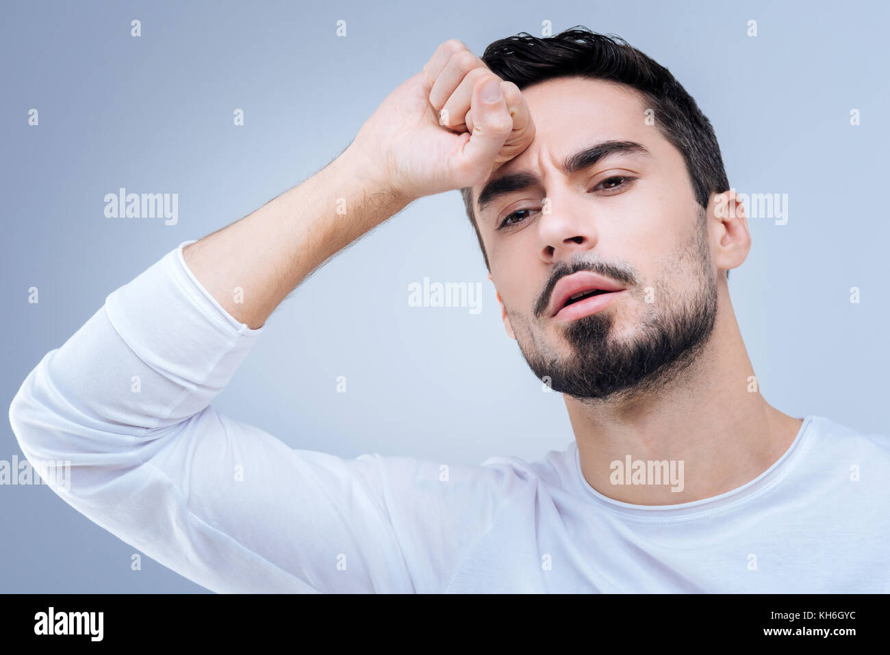 Curious young man thinking about an unusual situation at work Stock Photo