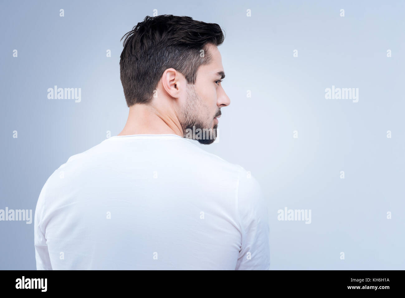 Serious bearded man looking to the right while turning away Stock Photo