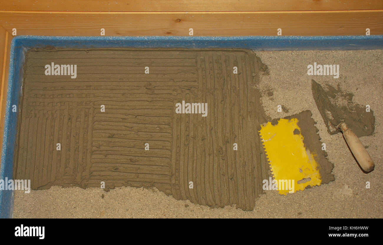 The corner of a new concrete floor in a wooden house. Floor tiling