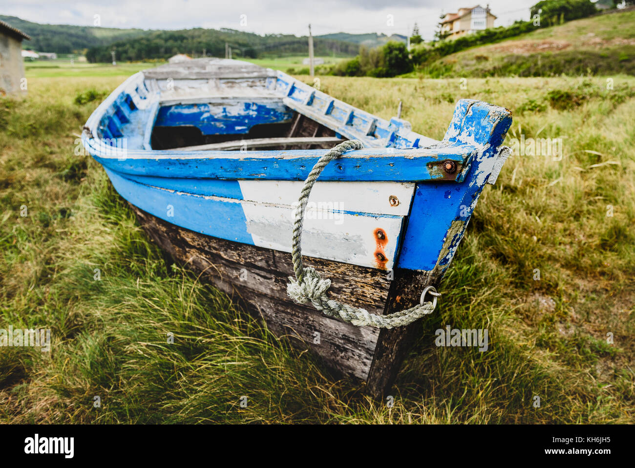 Old abandoned wooden fishing boat stranded on land and grass. Weathered ...