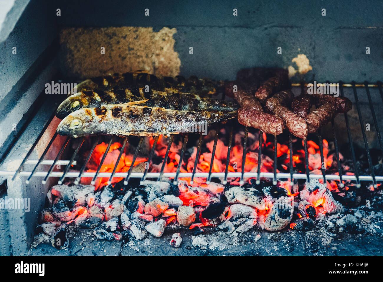 Barbecue in built barbecue grill fireplace with fish and chevaps. Concrete  bbq fireplace back yard fireplace in Croatia Stock Photo - Alamy