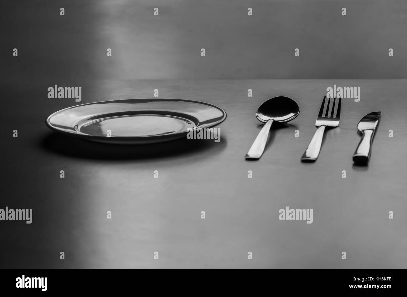 Empty plate with spoon, knife and fork  Stock Photo