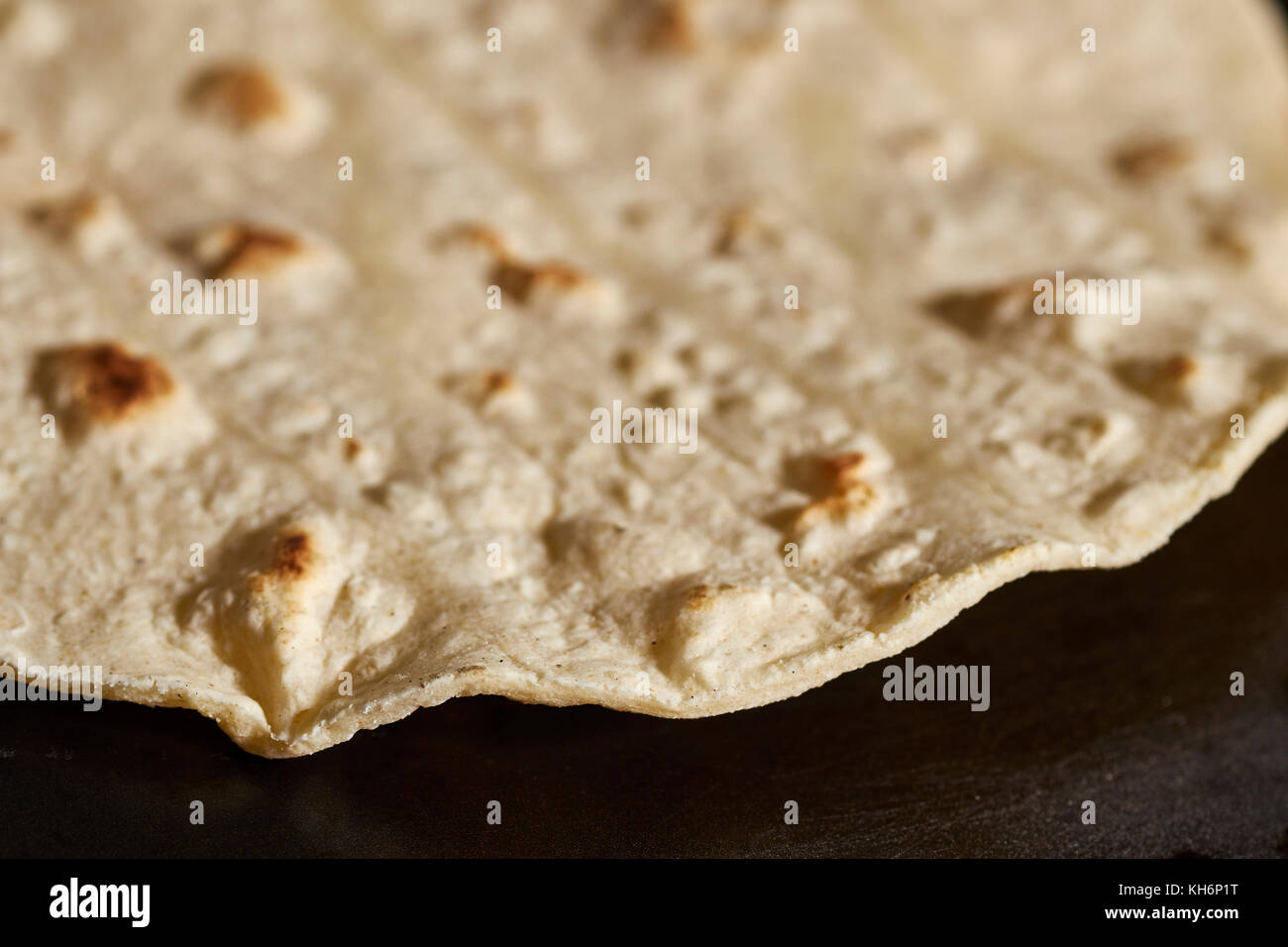 A corn tortilla cooking on a comal Stock Photo
