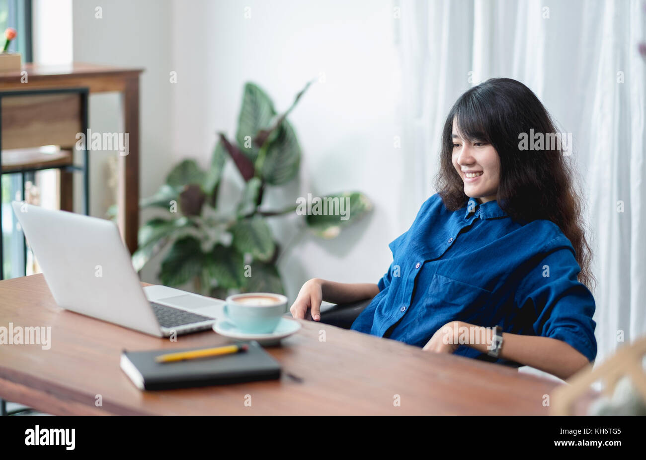 asia woman relax after working,female watching live streaming video on laptop drink coffee cup on wood table in cafe restaurant,working lifestyle outs Stock Photo