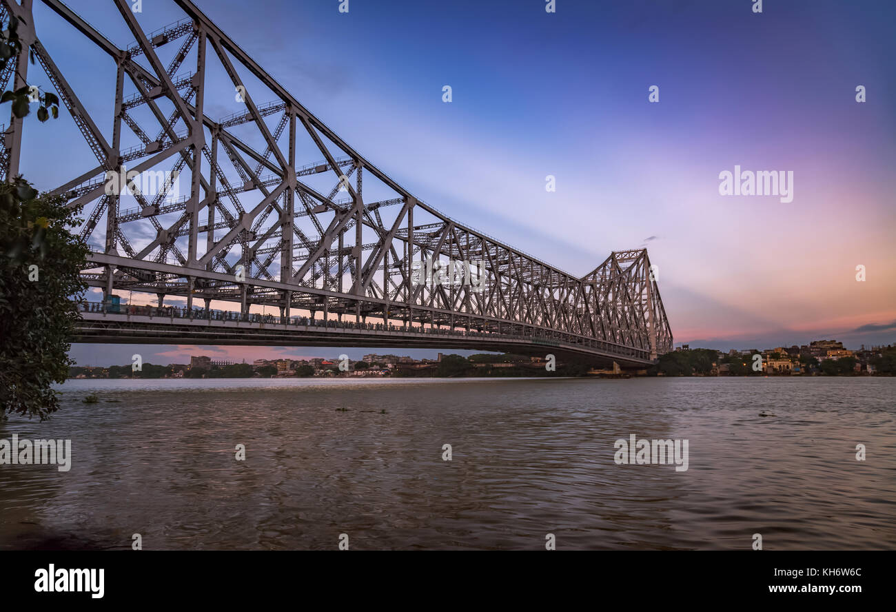 Howrah bridge Kolkata - The historic cantilever bridge on river Hooghly with moody sunrise sky Stock Photo