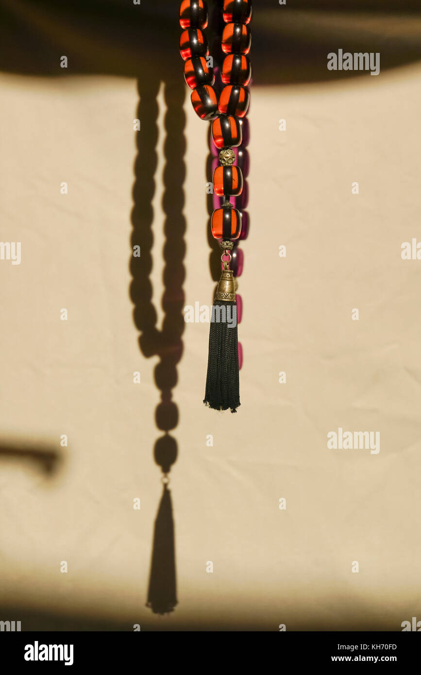 Red and black amber Worry beads or komboloi, kompoloi a string of beads manipulated with one or two hands and used to pass time in Greek and Cypriot c Stock Photo