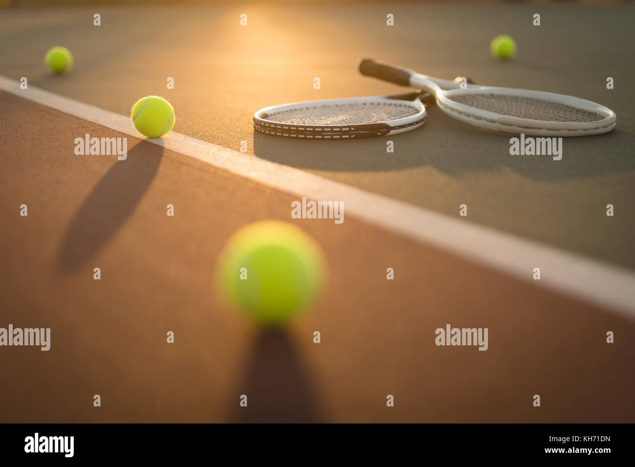 Tennis balls and rackets in ground on a sunny day Stock Photo