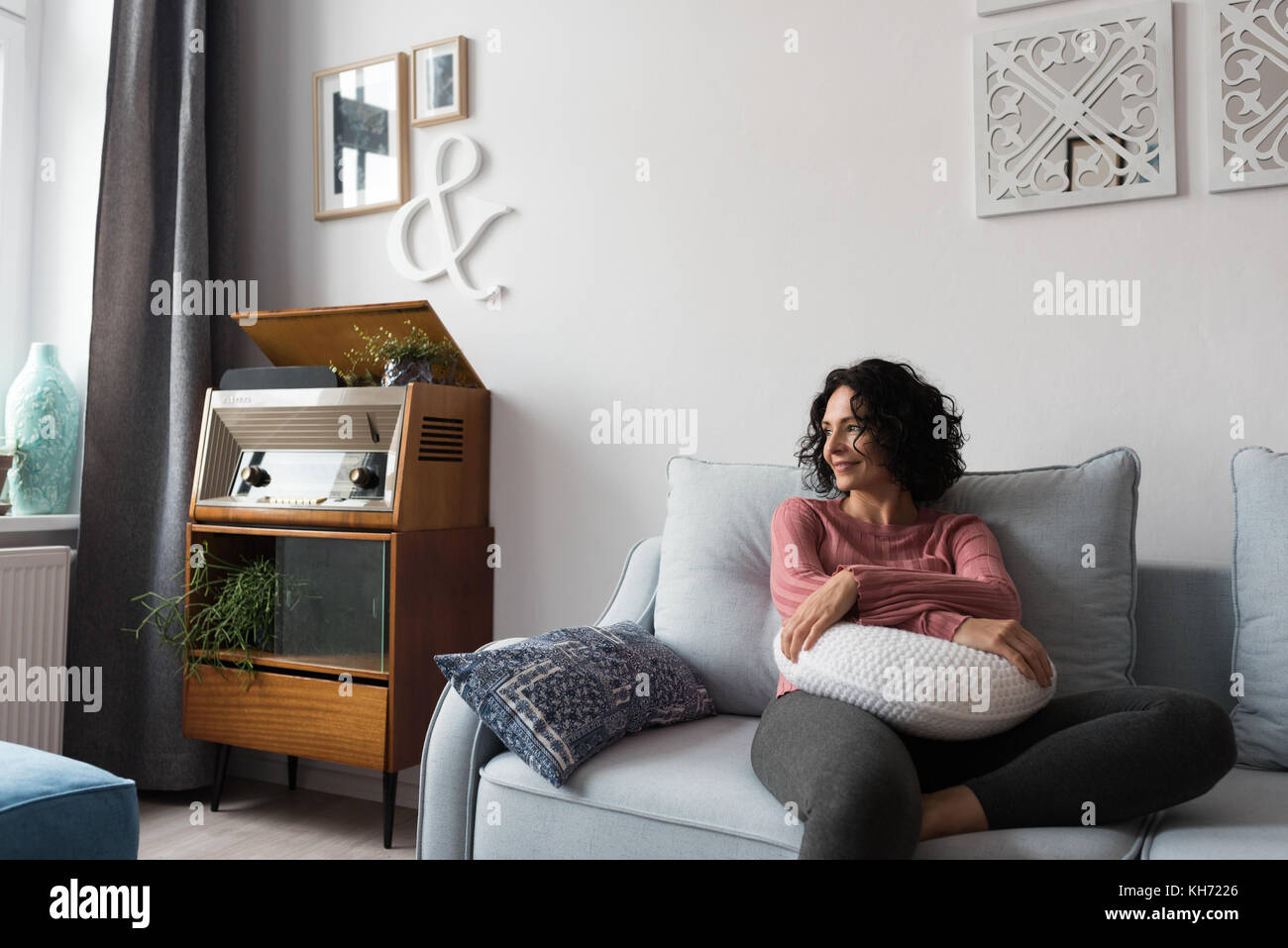 Beautiful woman relaxing on sofa at home Stock Photo - Alamy