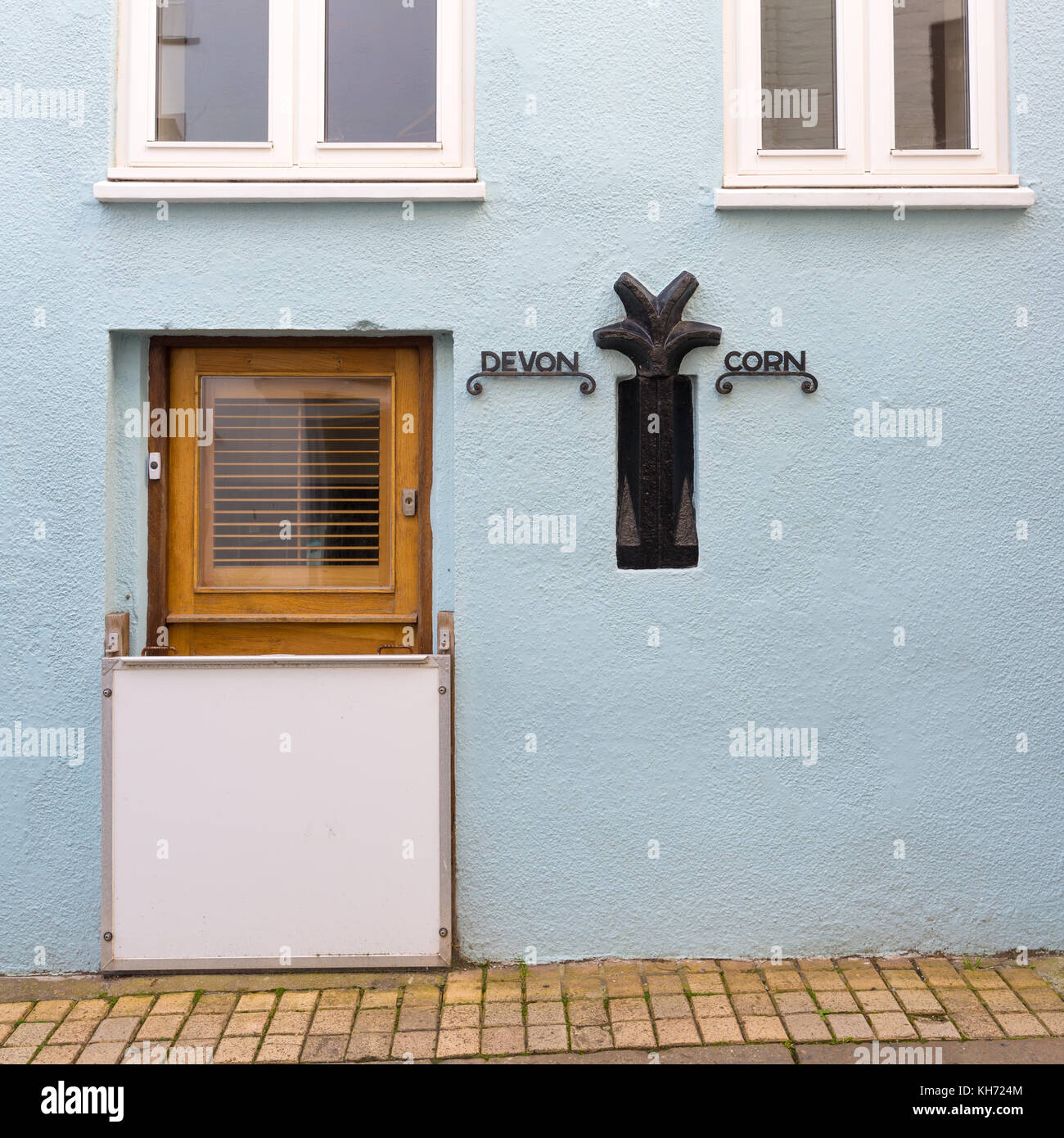 Former Devon Cornwall border in the wall of a quaint pastel blue coloured property at Cawsand Kingsand, southeast Cornwall, UK Stock Photo