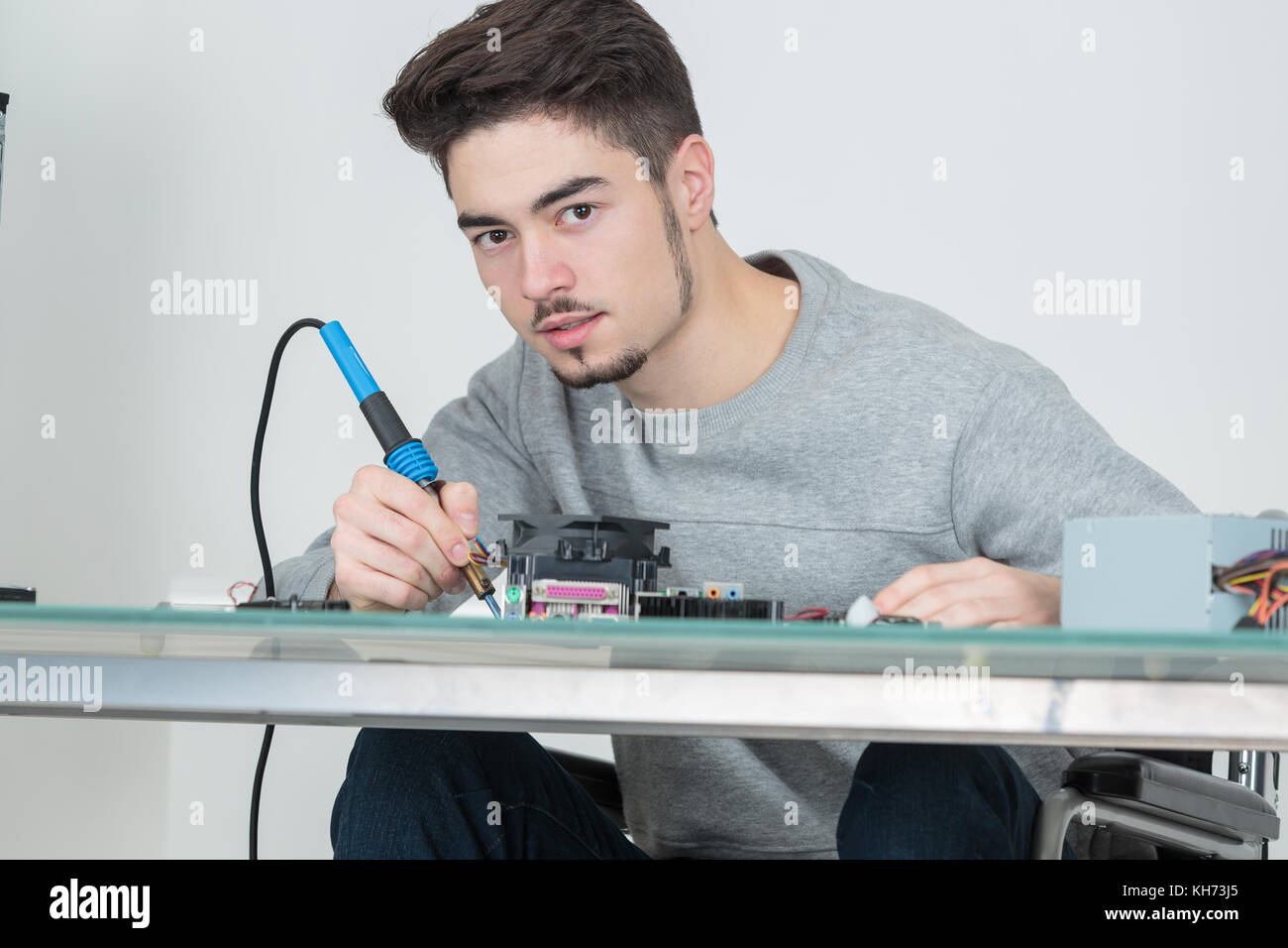 View your shopping cart. young man holding soldering iron Stock Photo. 