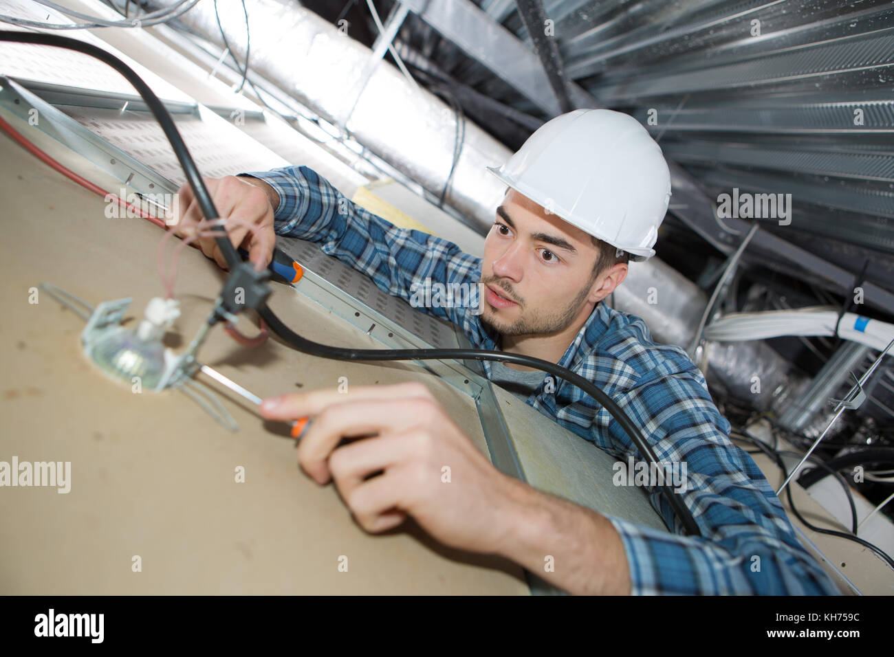 electrician repairing ceiling light Stock Photo - Alamy