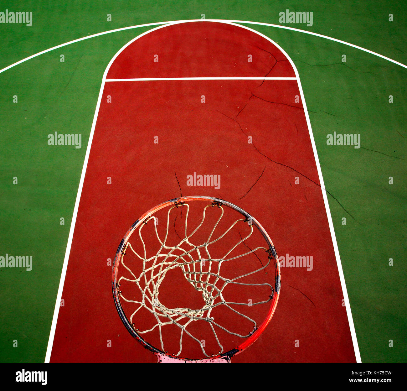 Pole aerial image of an outdoor basketball court. Includes rim, mesh, red key, white lines and green surface. Stock Photo