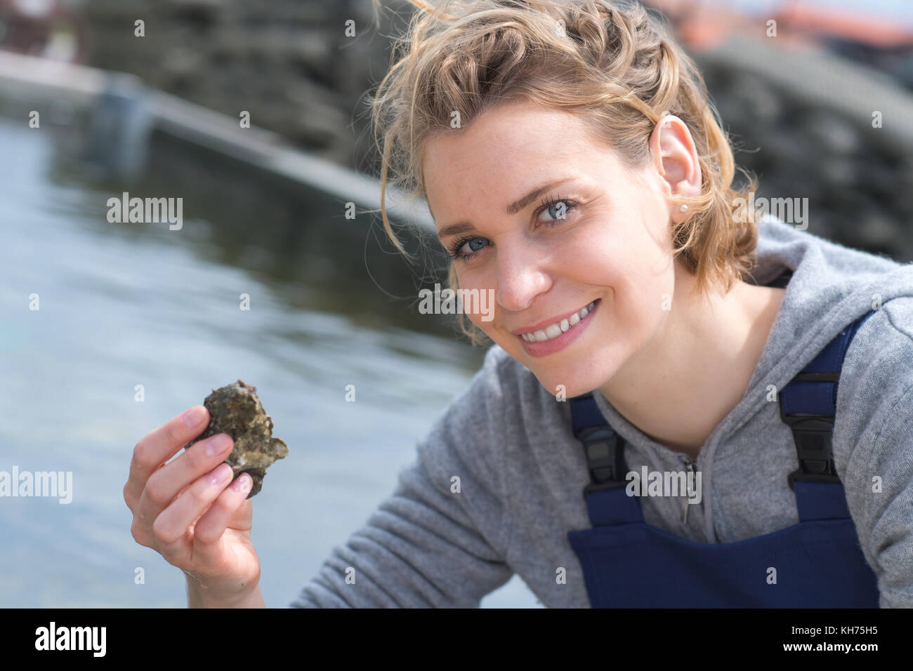 femael shell farmer holding fresh oysters Stock Photo