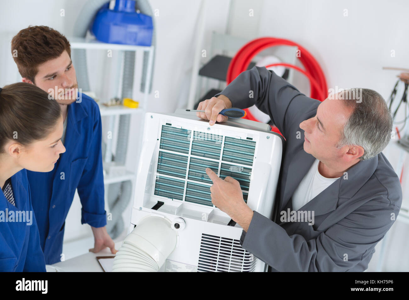 young students learning to adjust air conditioning system Stock Photo