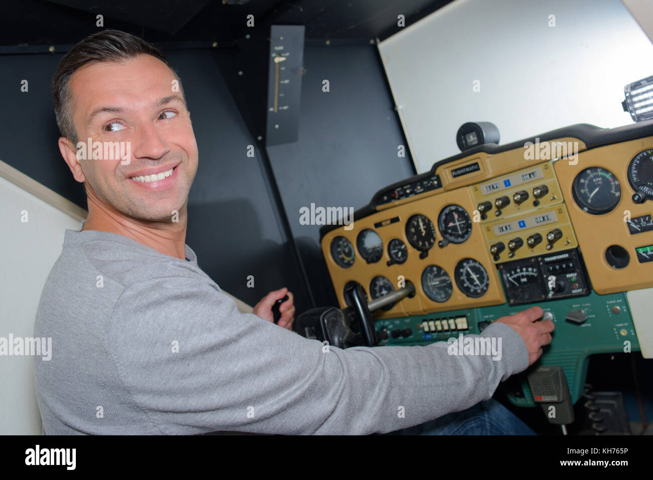 Man at control panel, turning and smiling Stock Photo - Alamy