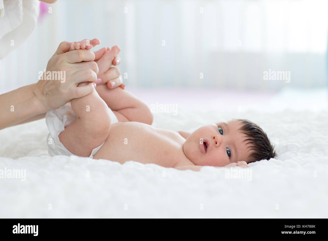 baby newborn is enjoying massage from mother Stock Photo