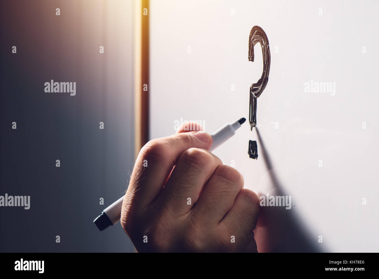 Confused businessman writing question mark on office whiteboard, selective focus Stock Photo