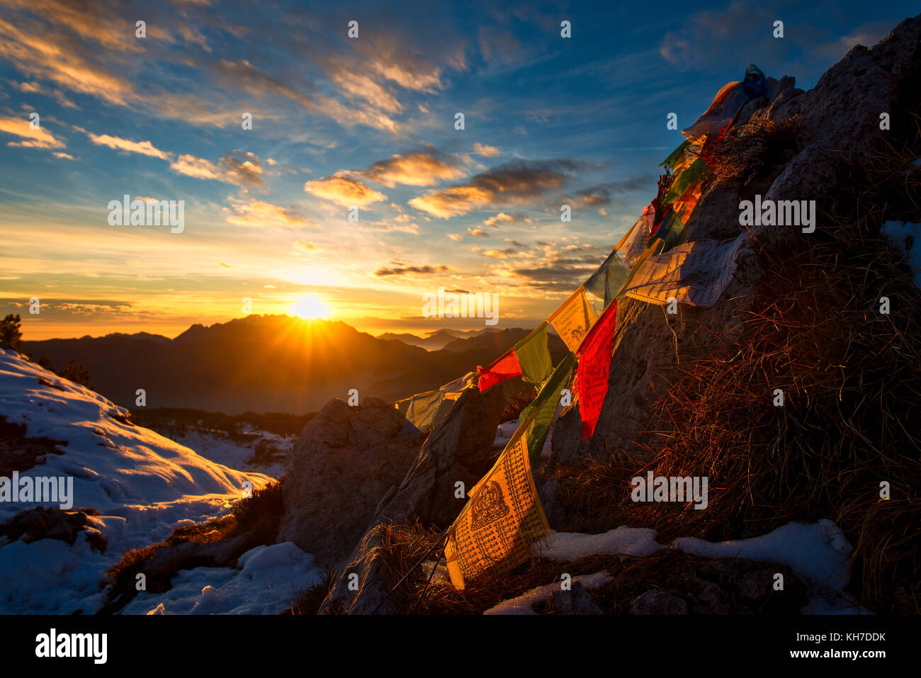 Flags of Tibetan prayers in the mountains with the colors of a warm sunset. Stock Photo