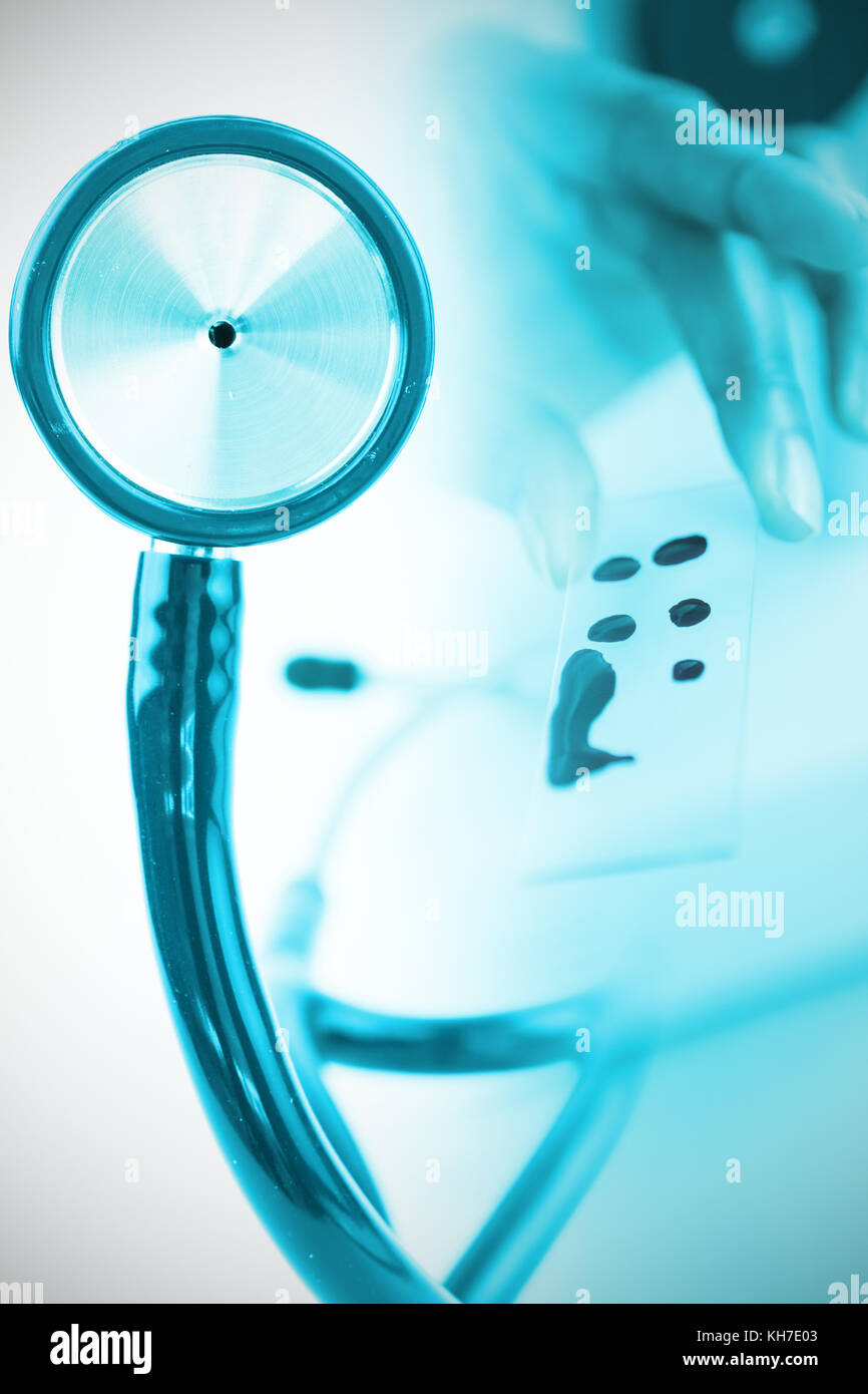 Part of the blue stethoscope against doctor holding microscope slide Stock Photo Alamy