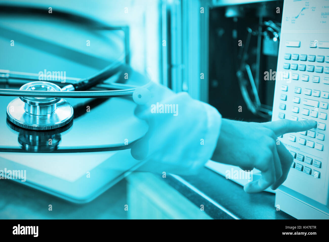 Stethoscope on digital tablet against doctor using a machine in ...