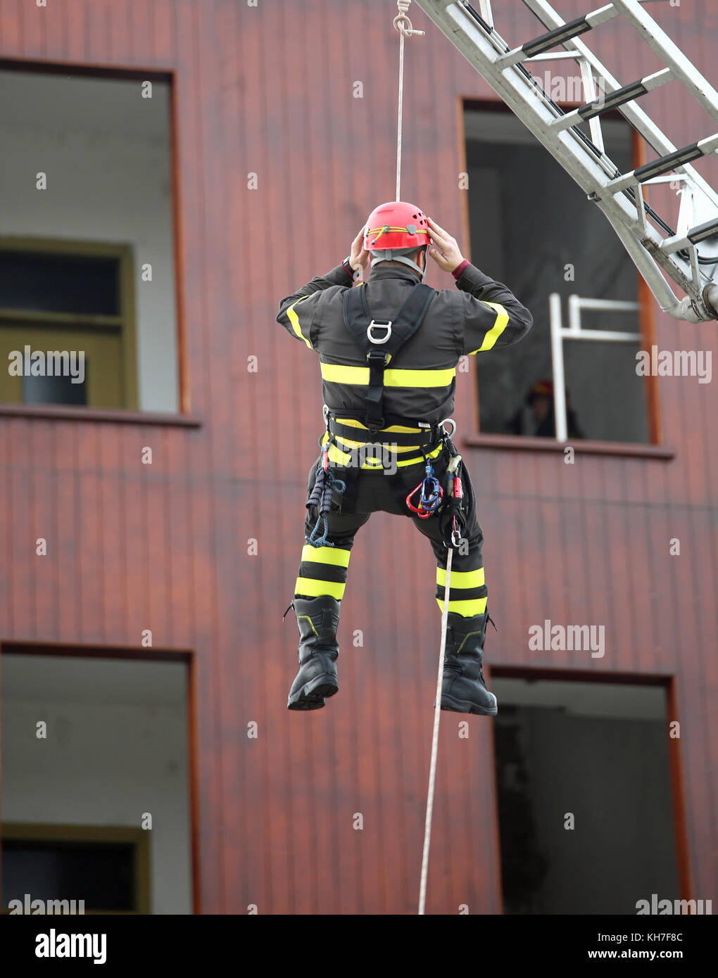 brave rescuer with red helmet descends from the platform during a ...