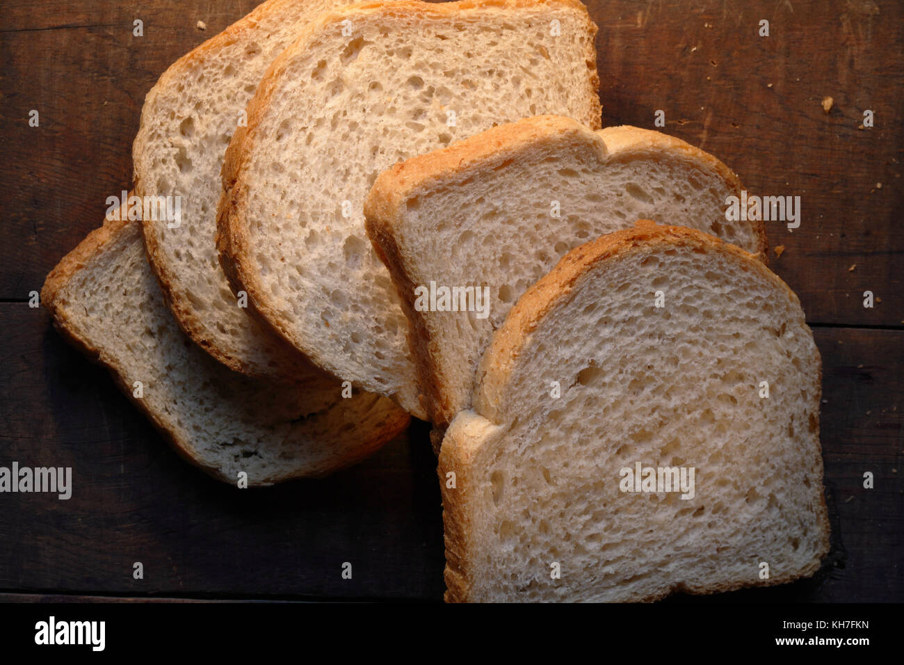 Few pieces of sliced white bread lying on dark wooden background Stock ...
