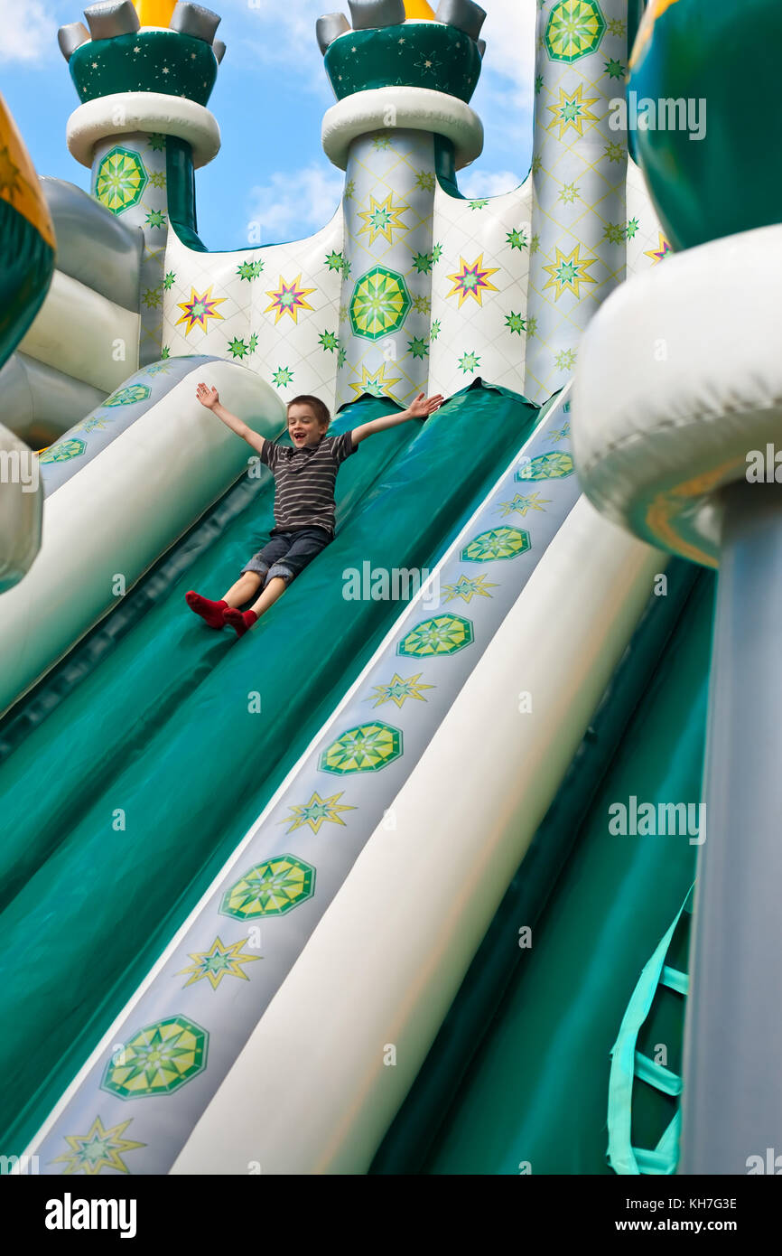 Young boy playing in inflatable playground Stock Photo - Alamy