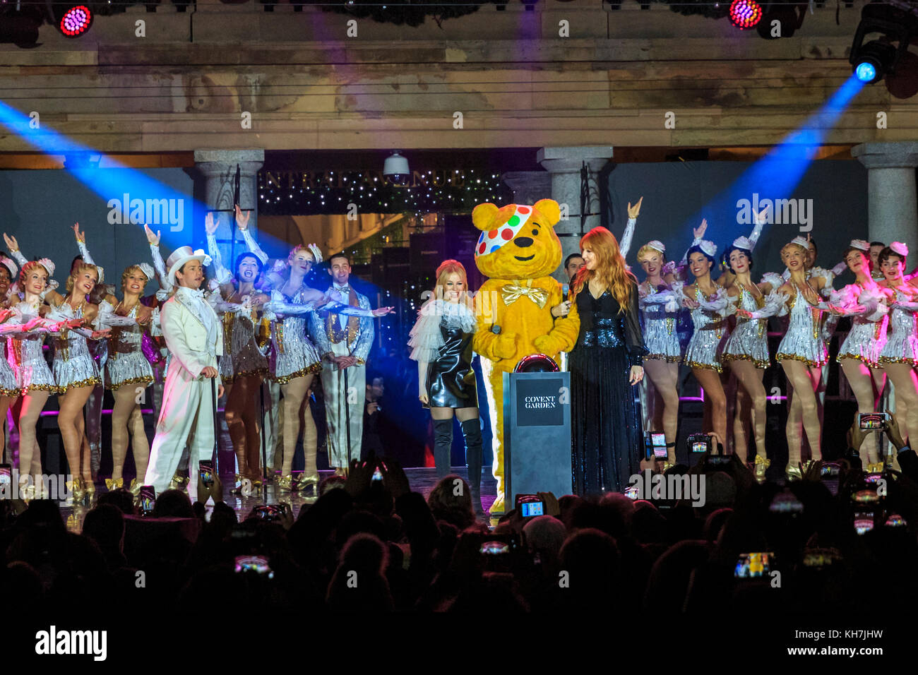 Covent Garden, London, UK, 14th Nov 2017. The Covent Garden Christmas lights 2017 are switched on by Pudsy with special guests, singer Kylie Minogue and designer Charlotte Tilbury. Festive celebrations include performances from the acclaimed hit West End musical 42nd Street performing numbers from the show. Pudsey and his special guests Kylie switch on the lights in collaboration with BBC Children in Need this year. The Piazza hosts London’s biggest hand-picked Christmas tree. Credit: Imageplotter News and Sports/Alamy Live News Stock Photo
