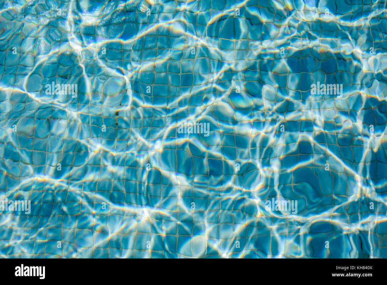The Sun reflection on the blue clear water ripples of swimming pool ...