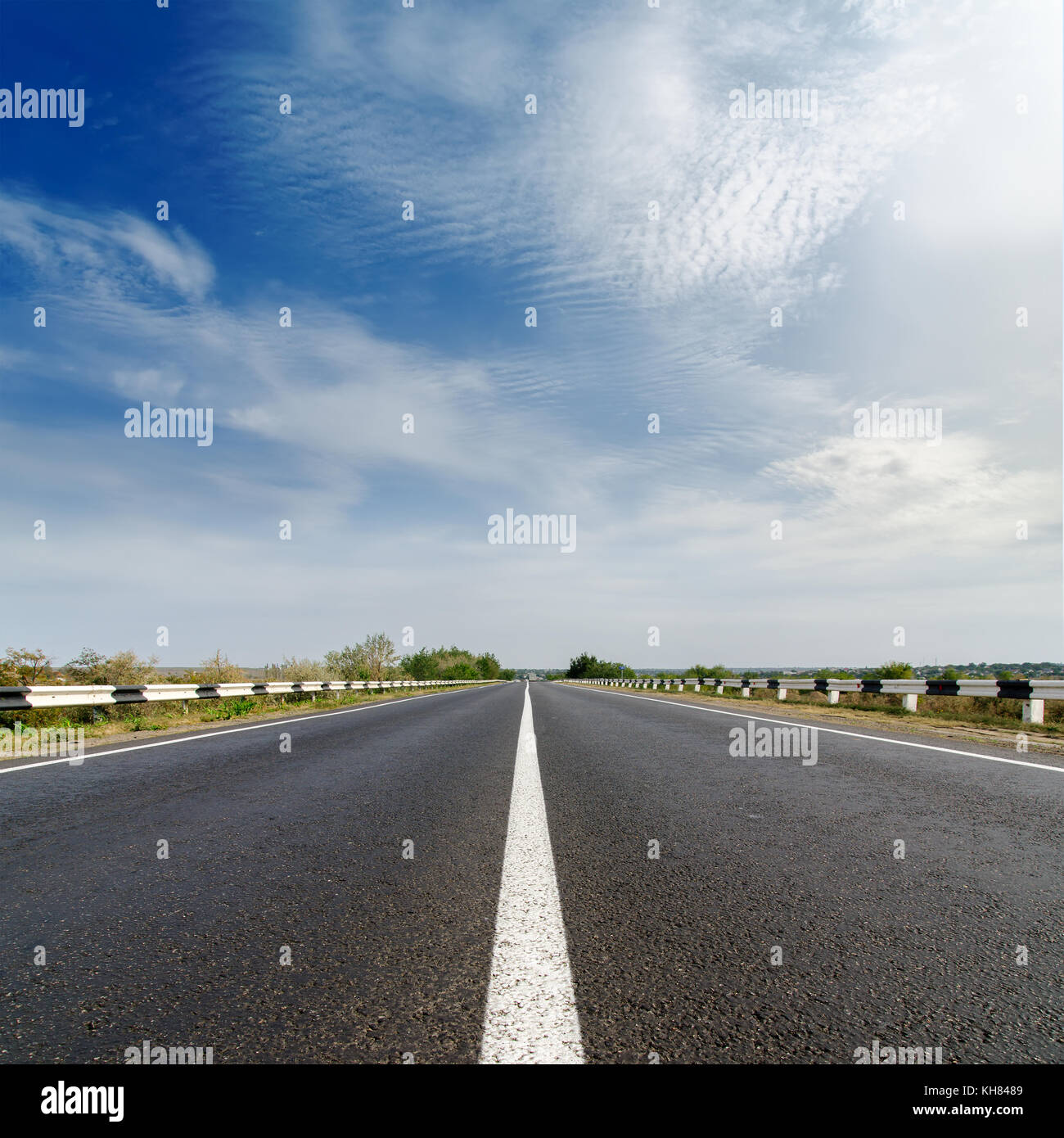 road closeup under cloudy blue sky Stock Photo - Alamy