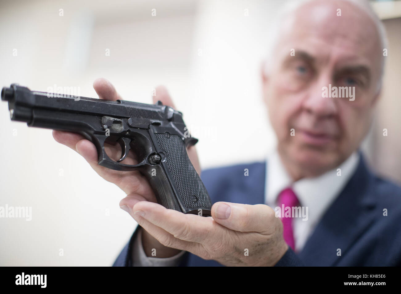 Police Crime Commissioner David Jamieson, holding a gun at Police Headquarters West Midlands Police Lloyd House, Birmingham, after Ray Wilkinson was prompted to hand in a cache of weapons belonging to his late uncle following the publicity surrounding the launch of the national firearms surrender. Stock Photo