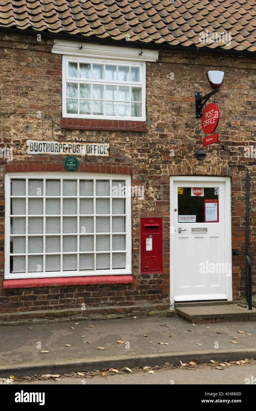 Exterior view of small rural village post office shop (closed today) with post box, signs, windows & doorway - Bugthorpe, Yorkshire, England, UK. Stock Photo