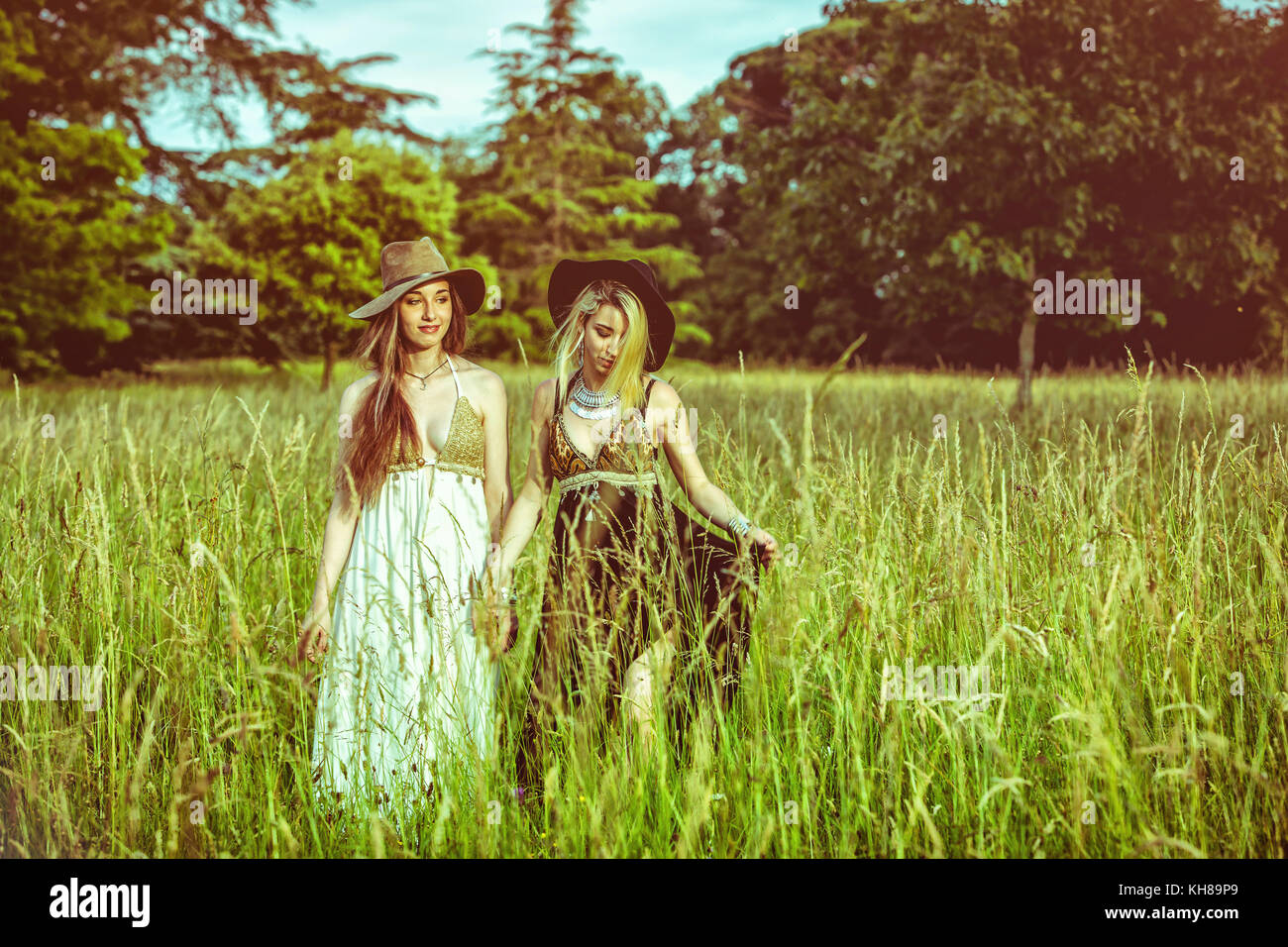 Portrait of two girls holding hands in a field Stock Photo - Alamy