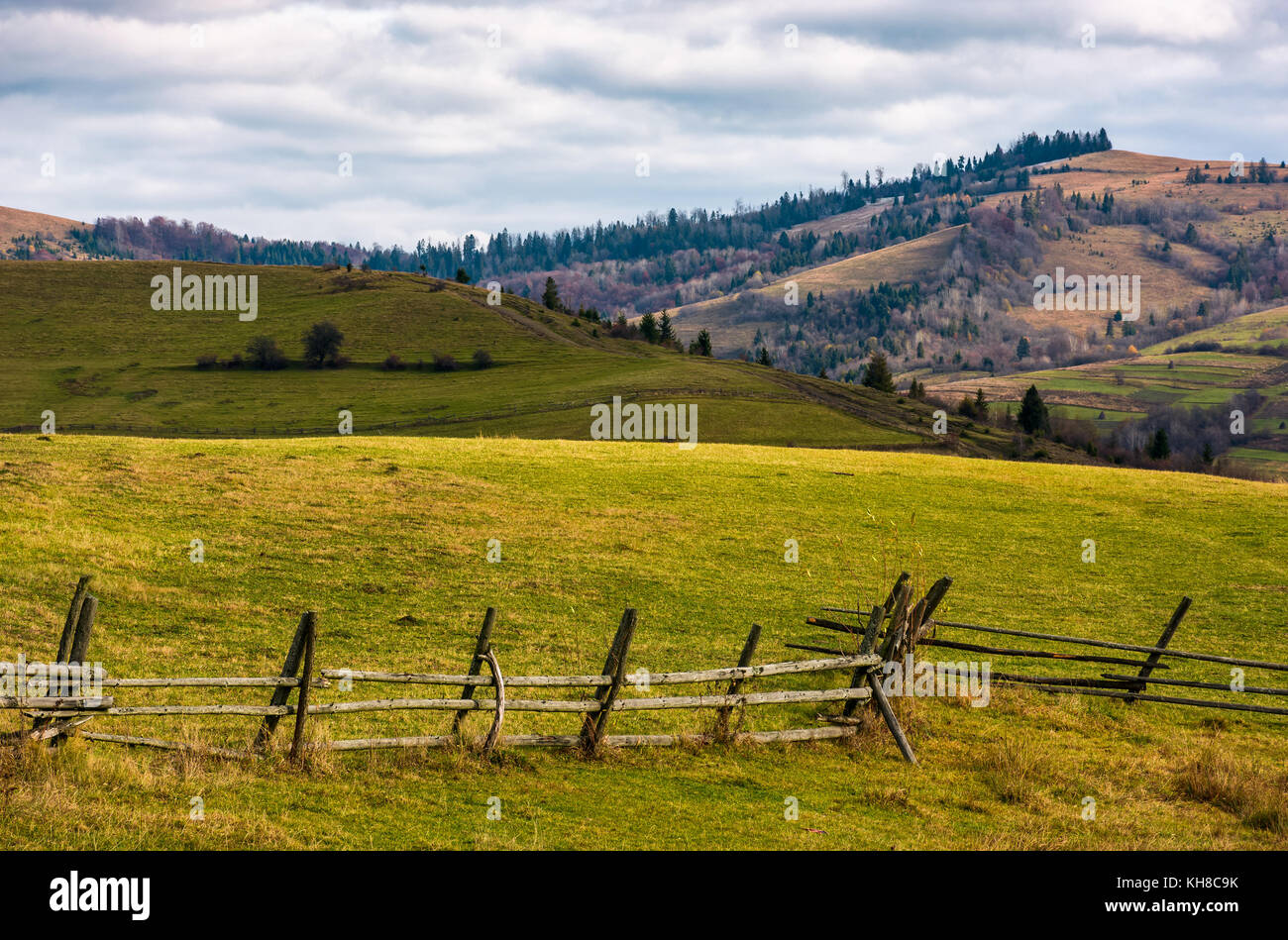 wooden fence on grassy rural hill in late autumn sunny day. beautiful ...