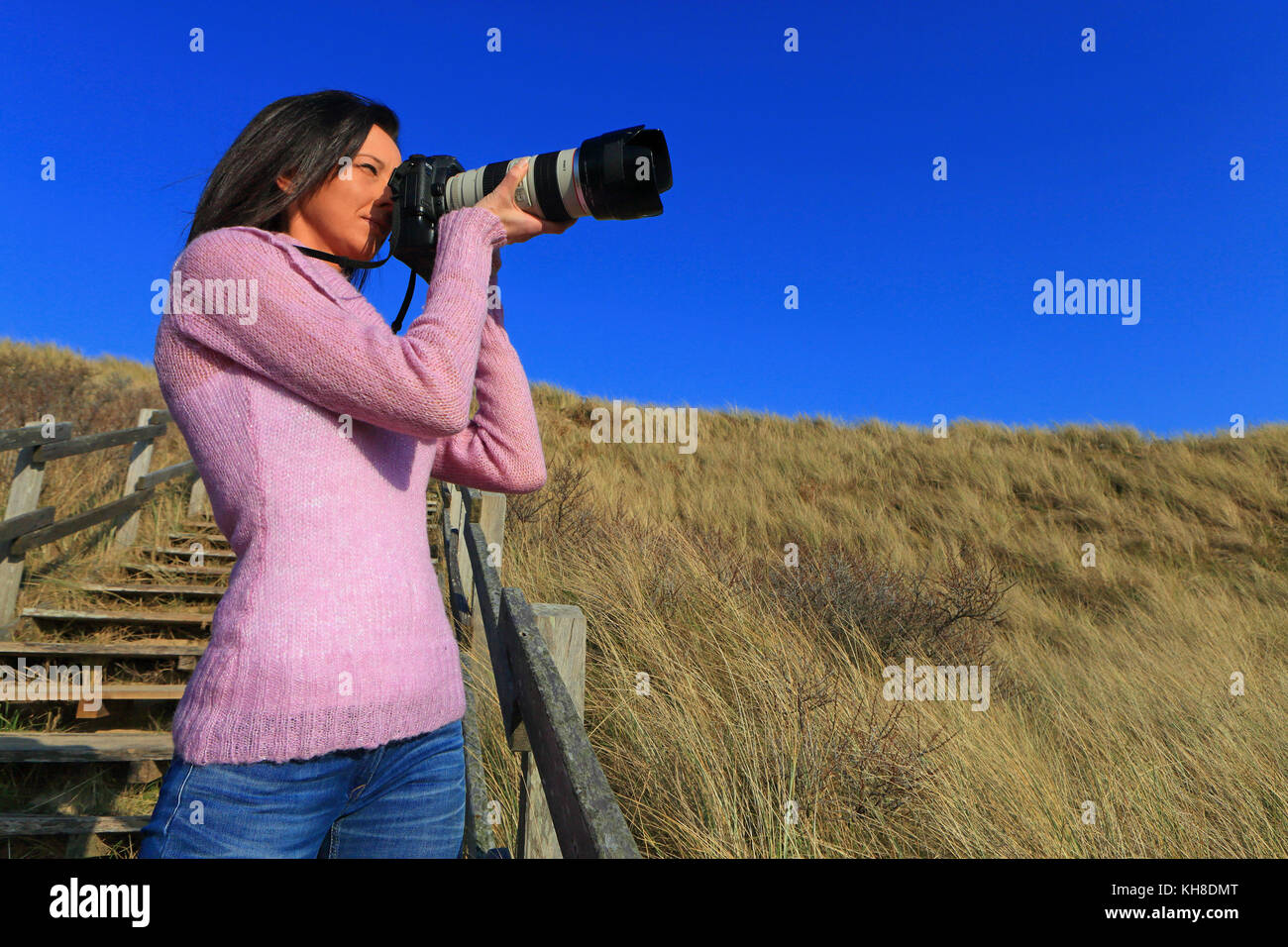 Woman at beach with professional camera Stock Photo - Alamy