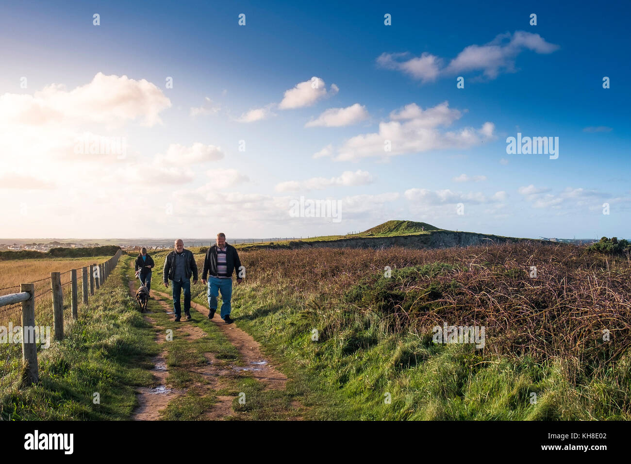 Men walkers walking along the South West Coast Path Footpath in Newquay Cornwall UK. Stock Photo