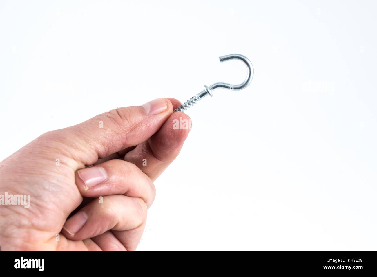 a small metal clip between the fingers Stock Photo