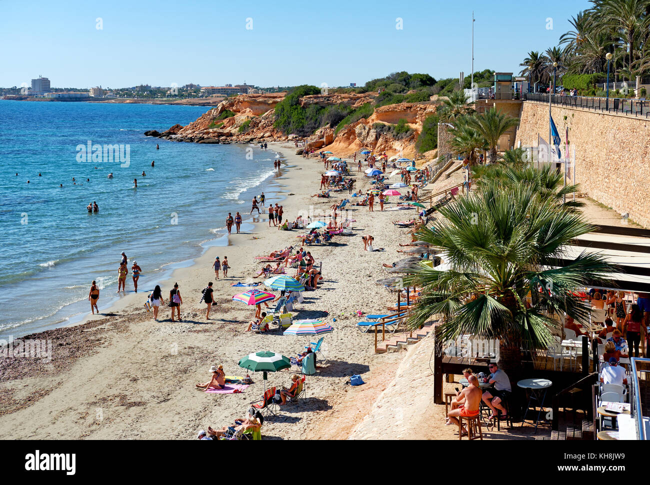 Punta Prima, Spain October 21, 2017 People sunbathing on the rocky