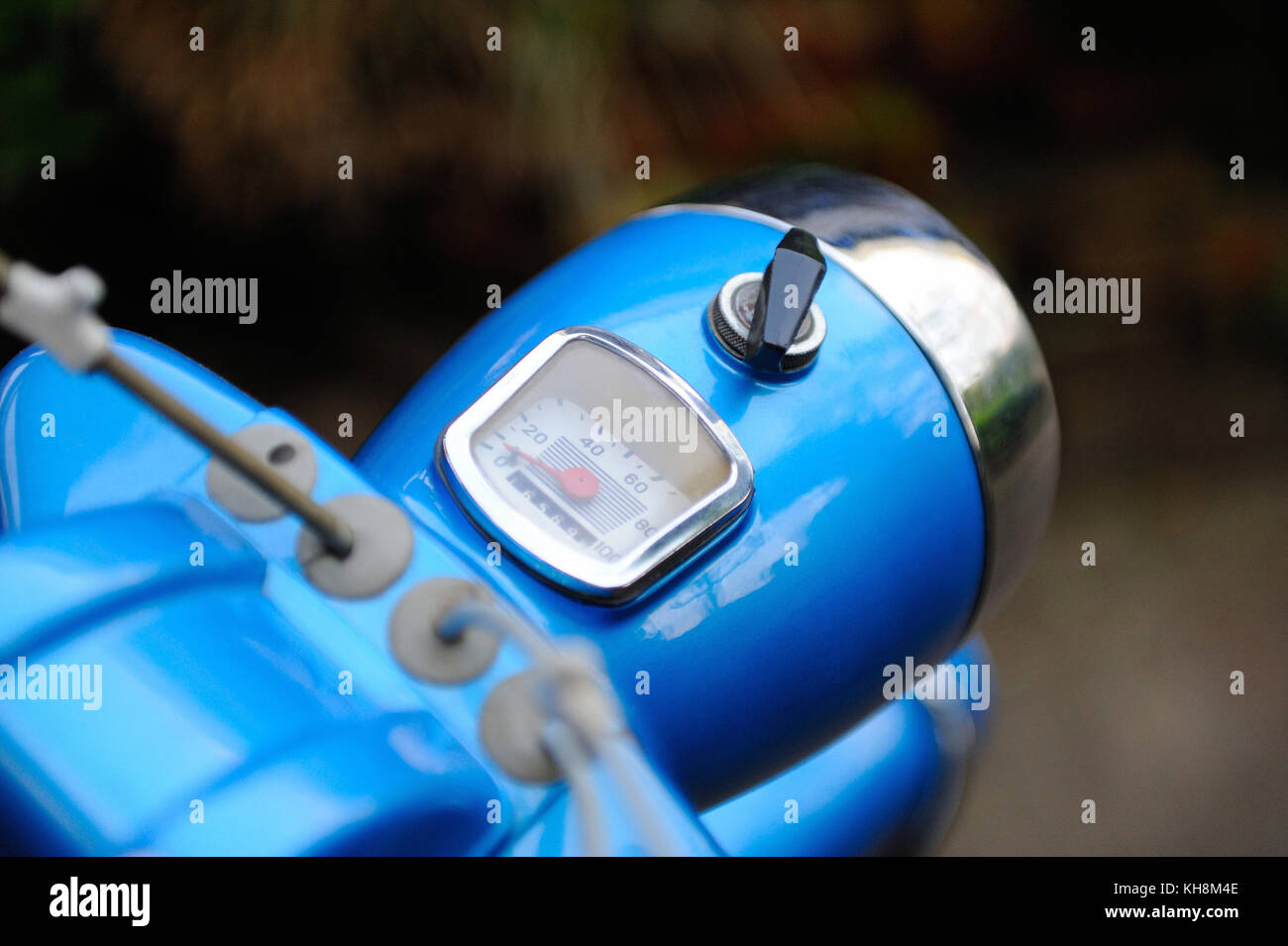 Retro moped cockpit with speedometer and ignition key with blurred background Stock Photo