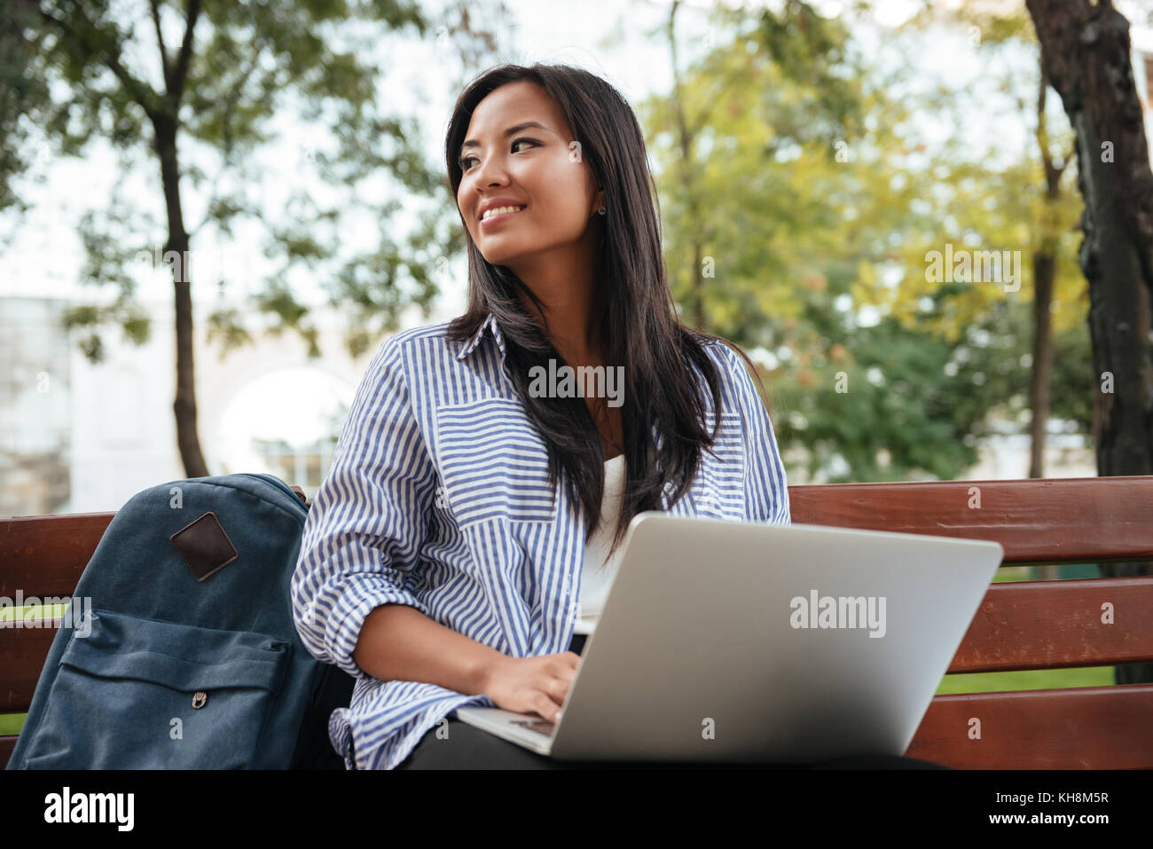 Portrait of young beautiful asian female student with laptop, sitting ...