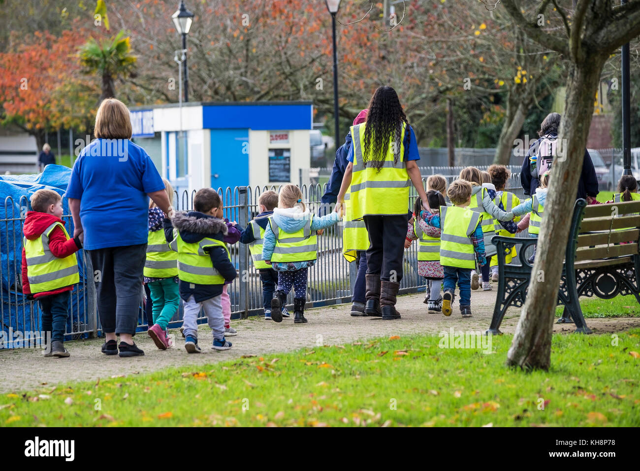 A group of pre-school children walking with their teachers and teaching assistants on a trip out. Stock Photo