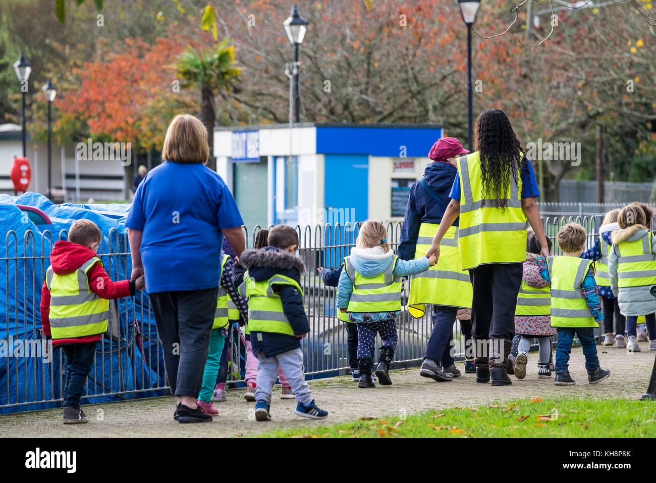 A group of pre-school children walking with their teachers and teaching assistants on a trip out. Stock Photo