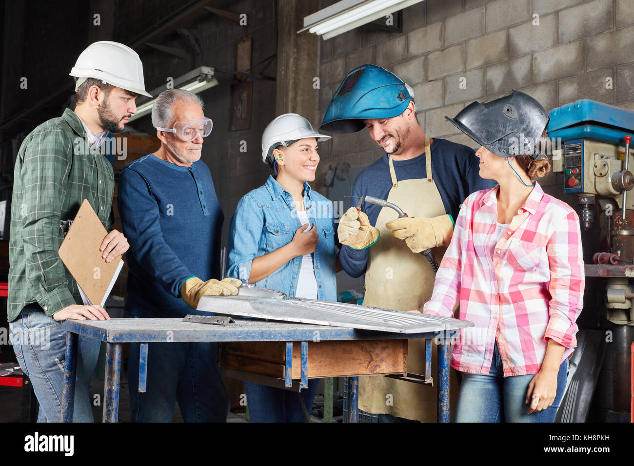 Welder team of workers with instructor during apprenticeship in metal factory Stock Photo