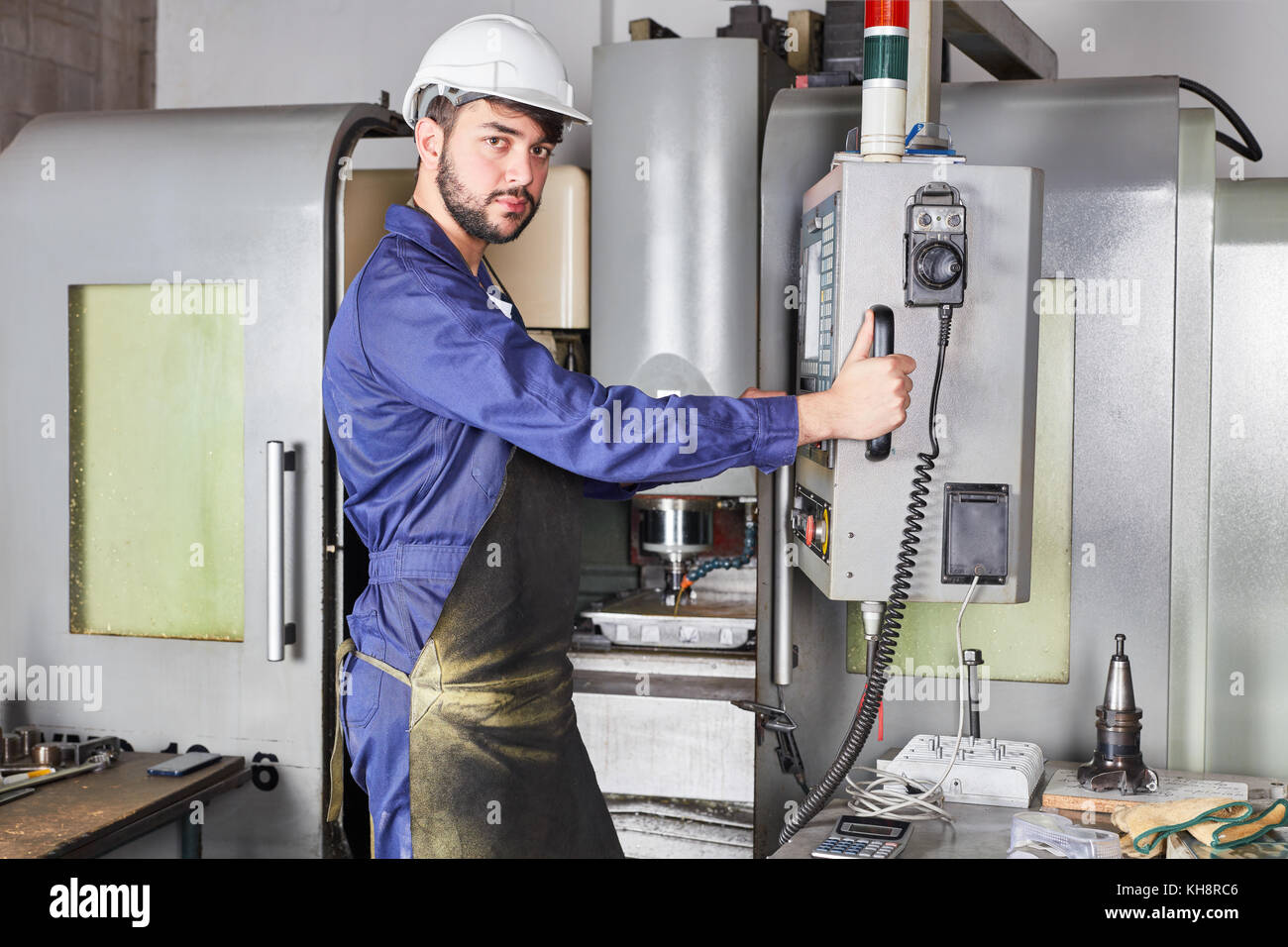 Man as blue collar worker with CNC machine tool manufacturing in factory Stock Photo