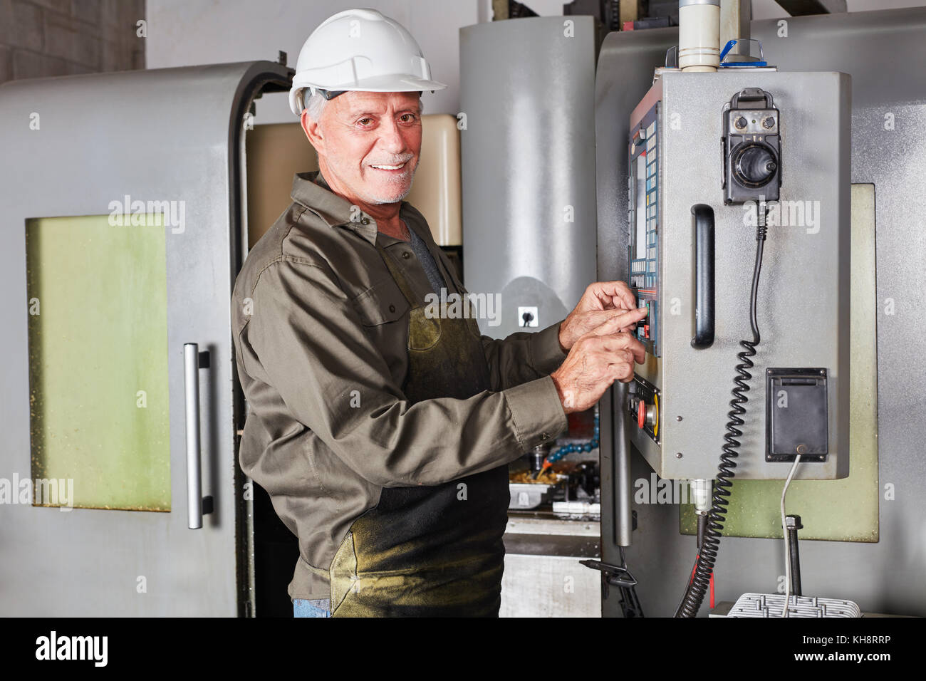 Senior man as blue collar worker and mechanist using CNC machine Stock Photo