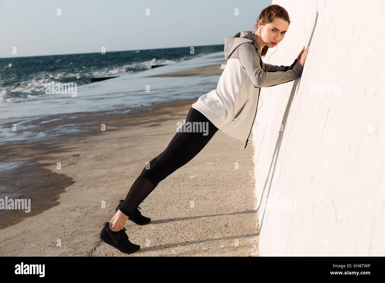 Fulllength photo of fit girl doing pushups while standing near white