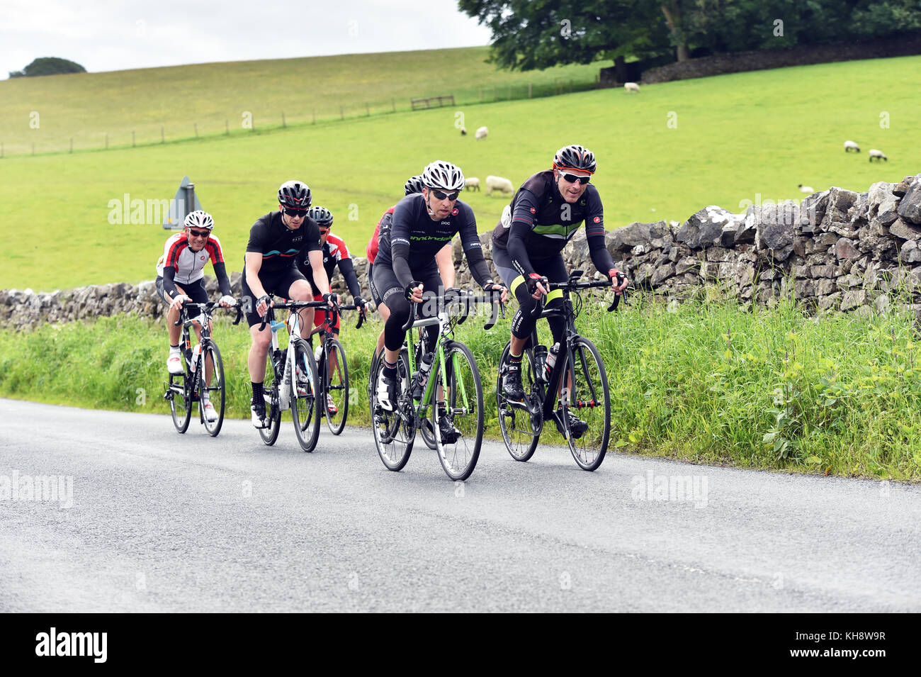 Cyclists riding on a country lane in the Yorkshire Dales, UK Stock Photo