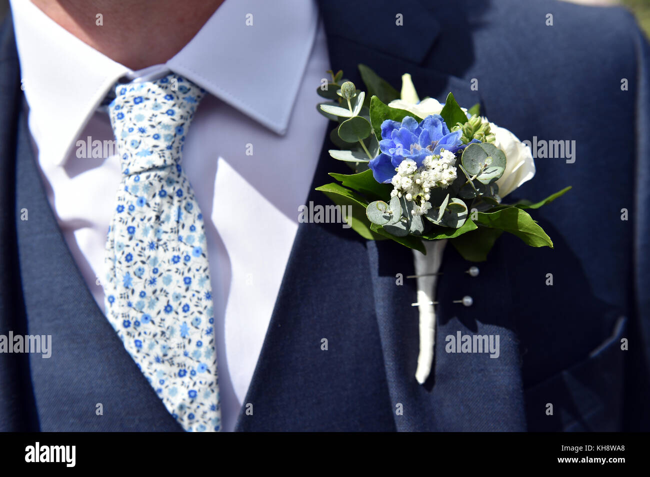 Close up of a groom's blue tie and flower button hole Stock Photo